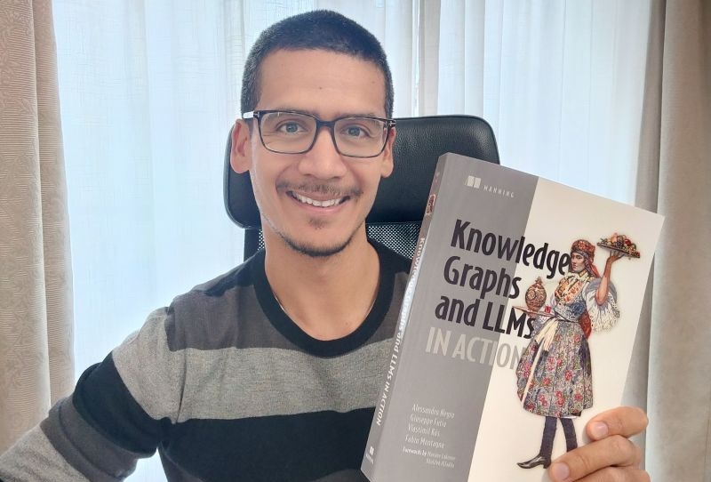 Dr. Giuseppe Futia holds up his new co-authored book on knowledge graphs and LLMs from Manning Publications